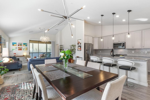 dining area featuring vaulted ceiling and a notable chandelier