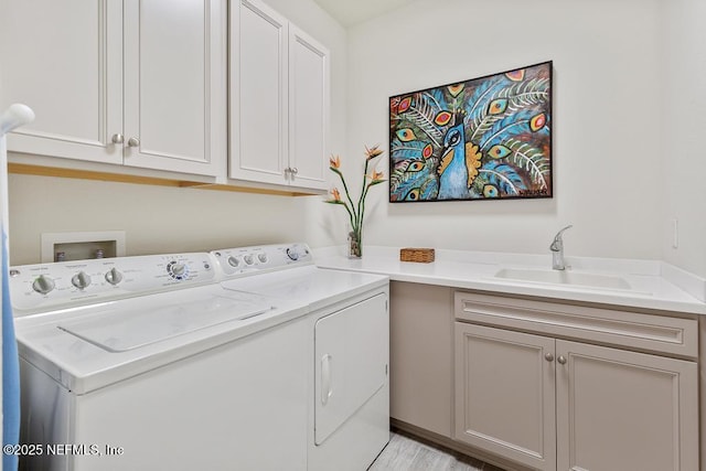 washroom with cabinets, sink, and washing machine and clothes dryer