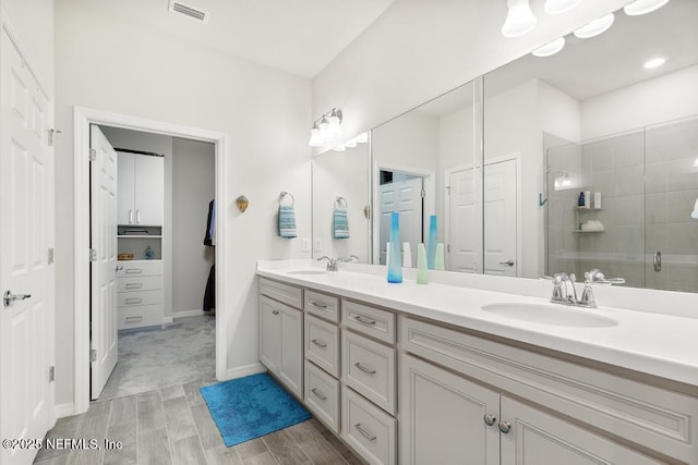 bathroom with vanity and a shower with door