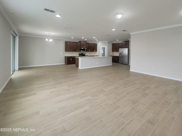 unfurnished living room with crown molding and a chandelier