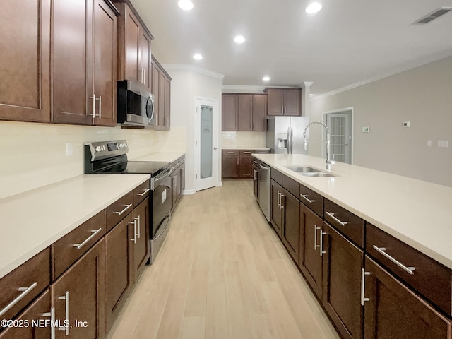 kitchen featuring light hardwood / wood-style floors, decorative backsplash, appliances with stainless steel finishes, ornamental molding, and sink