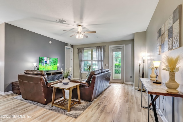 living room with ceiling fan and light hardwood / wood-style flooring