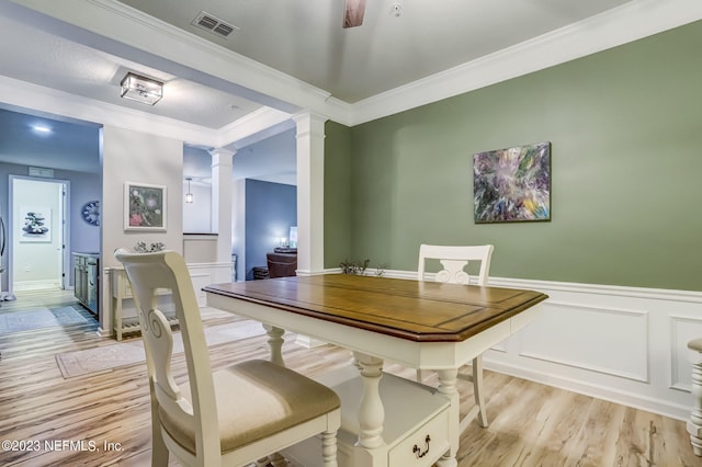 dining area featuring ceiling fan, crown molding, ornate columns, and light wood-type flooring