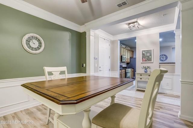 dining space featuring crown molding and light hardwood / wood-style floors