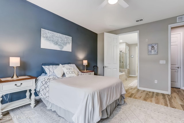 bedroom featuring ceiling fan, light hardwood / wood-style floors, and connected bathroom