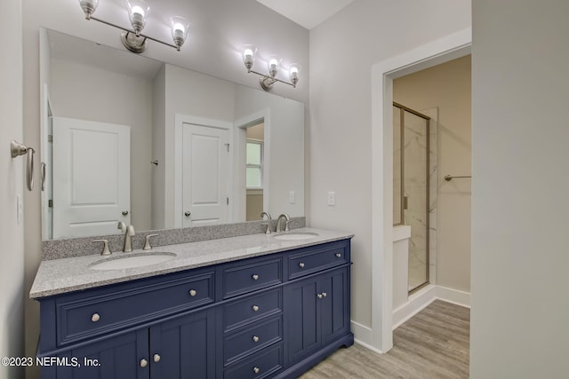 bathroom with hardwood / wood-style floors, walk in shower, and vanity