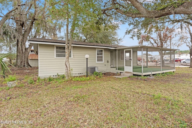 back of house with a yard, a sunroom, and central AC unit