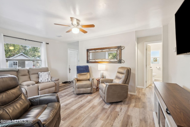 living room with ceiling fan and light hardwood / wood-style flooring