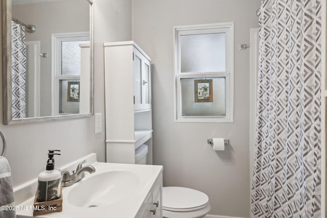 bathroom featuring toilet, a shower with shower curtain, and vanity