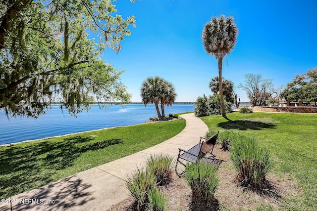 view of community featuring a water view and a lawn