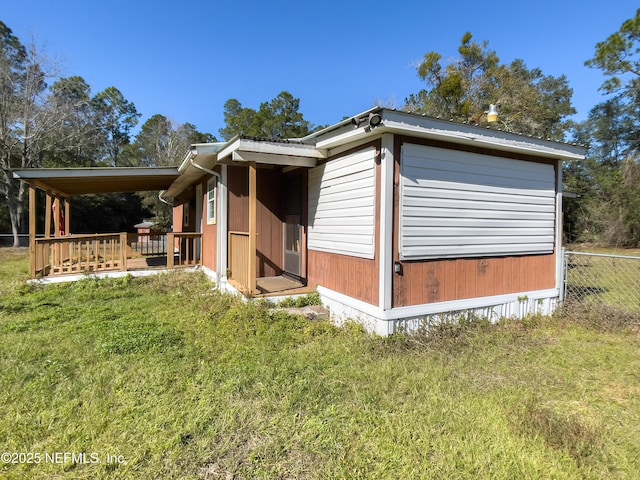 view of home's exterior with a wooden deck and a lawn