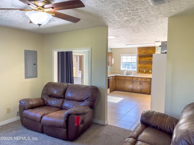 tiled living room featuring electric panel, a textured ceiling, ceiling fan, and sink