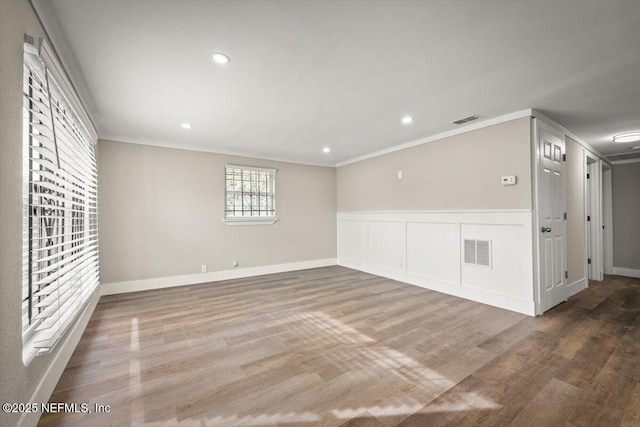 spare room featuring crown molding and hardwood / wood-style floors