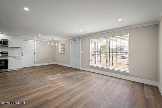 unfurnished living room featuring a notable chandelier, crown molding, and hardwood / wood-style flooring