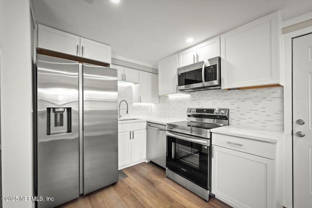 kitchen with appliances with stainless steel finishes, white cabinets, and sink