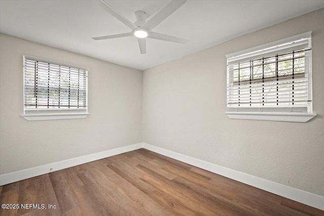 empty room featuring ceiling fan, a healthy amount of sunlight, and hardwood / wood-style floors