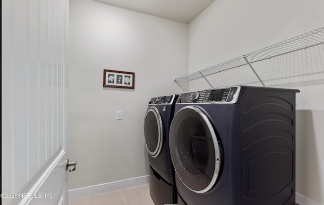 laundry area featuring light tile patterned flooring and washer and clothes dryer