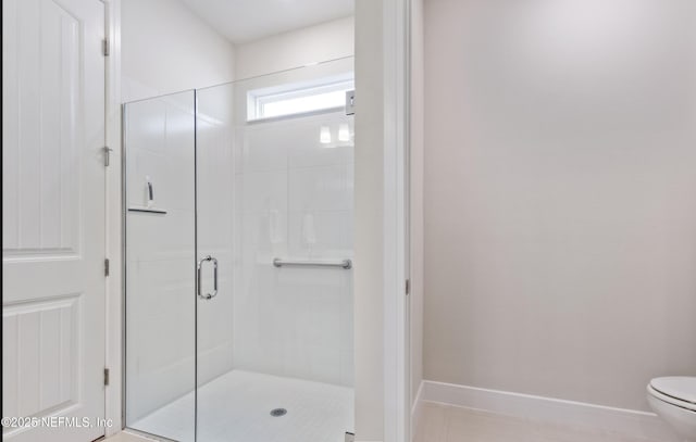 bathroom featuring toilet, an enclosed shower, and tile patterned floors