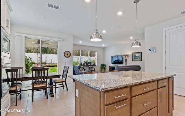 kitchen featuring stainless steel appliances, white cabinets, ceiling fan, a kitchen island, and pendant lighting