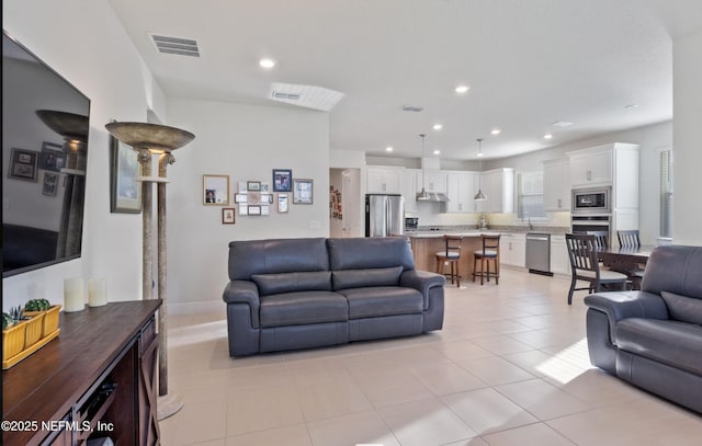 living room featuring sink and light tile patterned floors