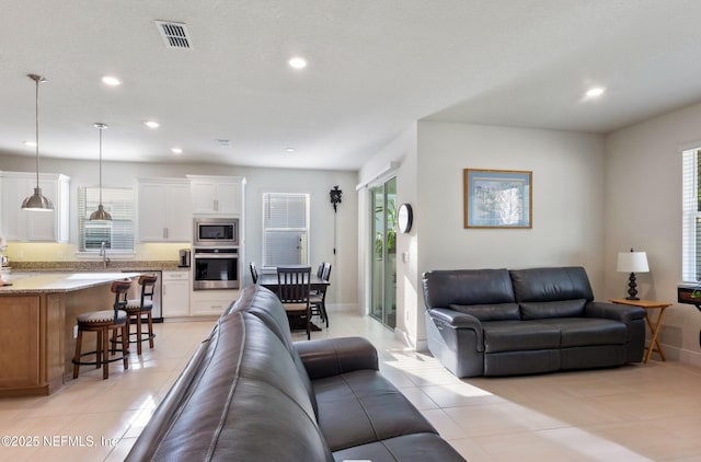 living room featuring light tile patterned floors and sink