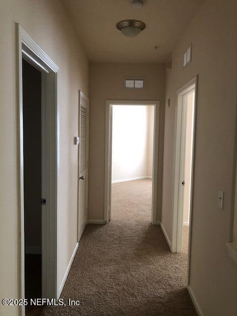 hall with light colored carpet