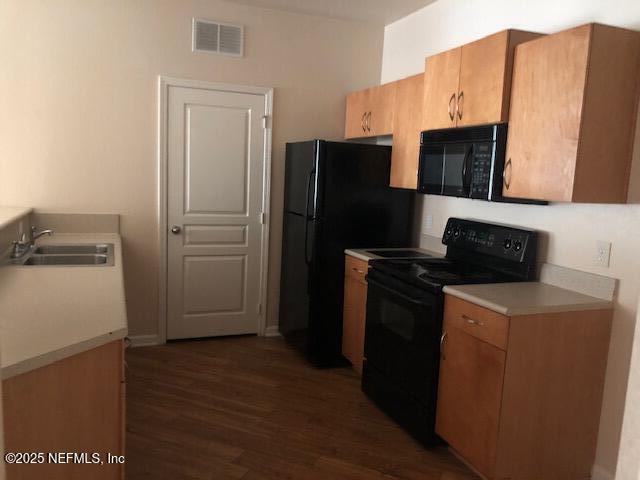 kitchen featuring sink, black appliances, and dark hardwood / wood-style floors