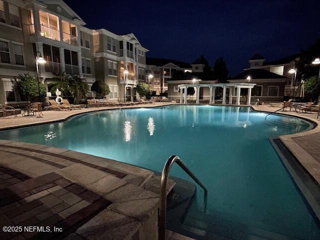 pool at twilight with a patio area