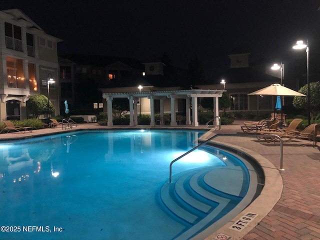 pool at twilight with a pergola and a patio