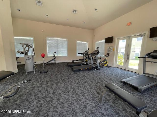 gym featuring french doors, high vaulted ceiling, and dark colored carpet