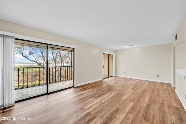 unfurnished room featuring a textured ceiling and light wood-type flooring