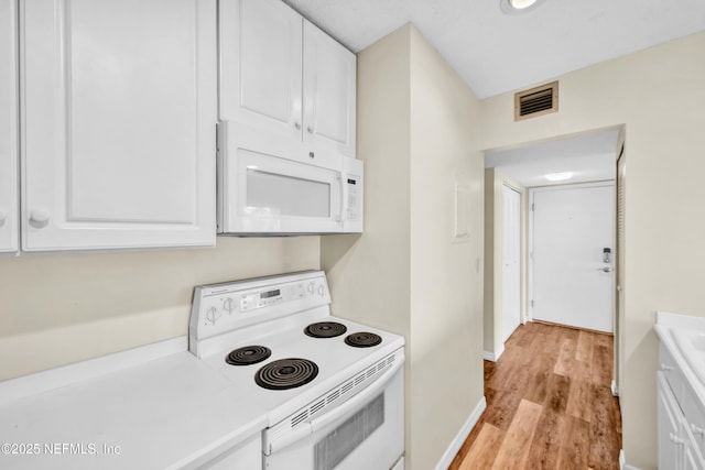 kitchen featuring white cabinets, white appliances, and light hardwood / wood-style flooring