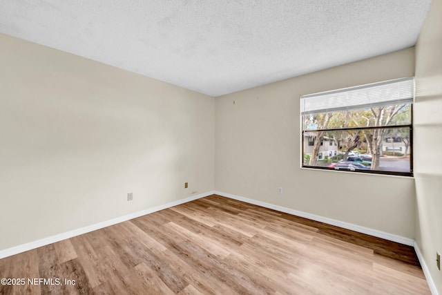 empty room featuring a textured ceiling and light wood-type flooring