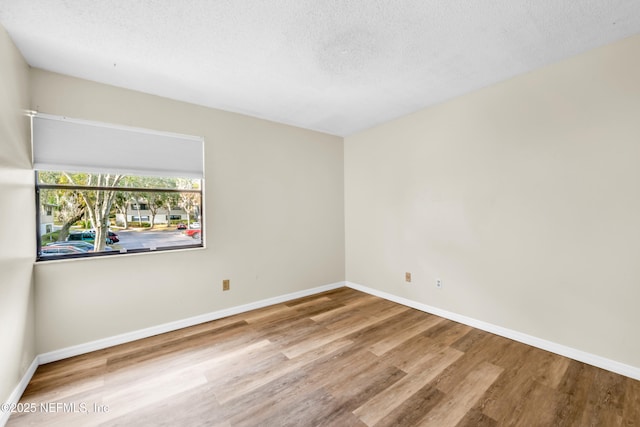 spare room with hardwood / wood-style flooring and a textured ceiling