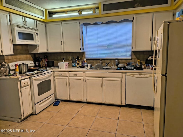 kitchen featuring sink, white appliances, light tile patterned floors, and white cabinets