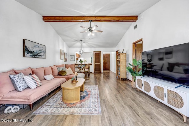 living room with ceiling fan, hardwood / wood-style flooring, and beam ceiling