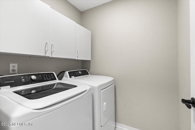 laundry area with cabinets and washer and clothes dryer