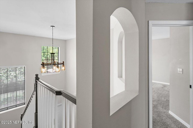 corridor featuring carpet floors and a chandelier