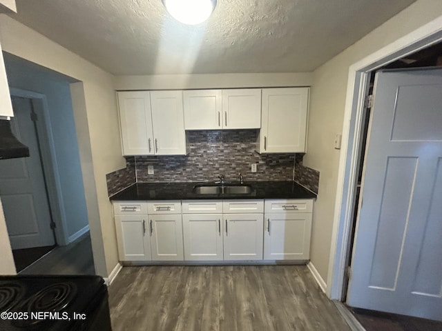 kitchen with white cabinets, decorative backsplash, dark wood-type flooring, and sink