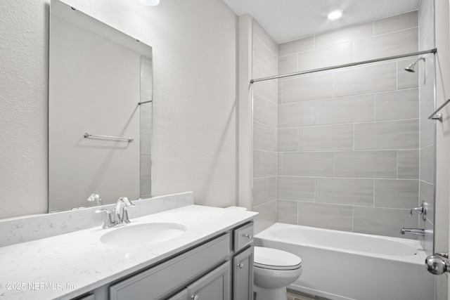 full bathroom with toilet, vanity, and tiled shower / bath combo