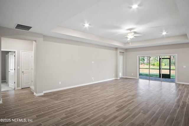 spare room featuring ceiling fan and a raised ceiling