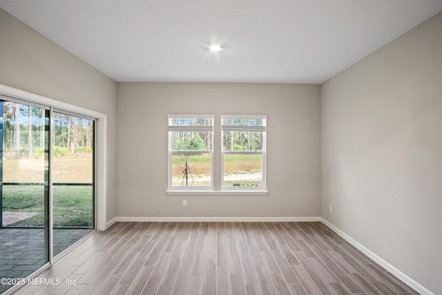 unfurnished room featuring a wealth of natural light and light hardwood / wood-style floors