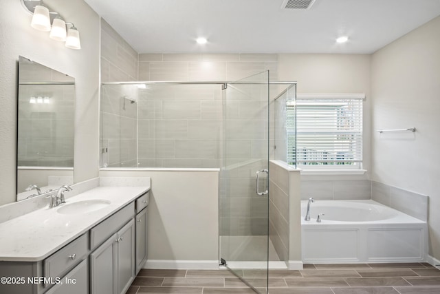 bathroom with vanity and shower with separate bathtub