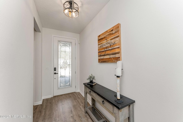 foyer entrance with a textured ceiling and light hardwood / wood-style flooring