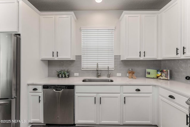 kitchen featuring stainless steel appliances, white cabinets, tasteful backsplash, and sink