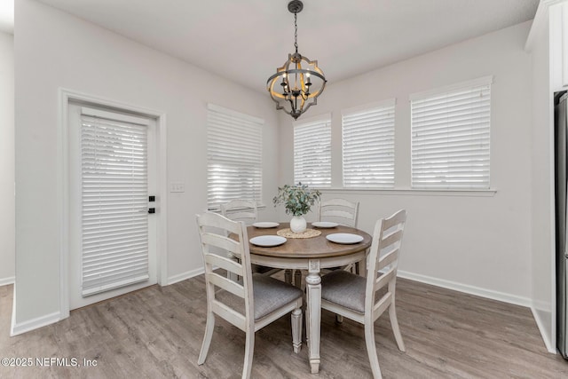 dining space featuring light wood-type flooring and a chandelier