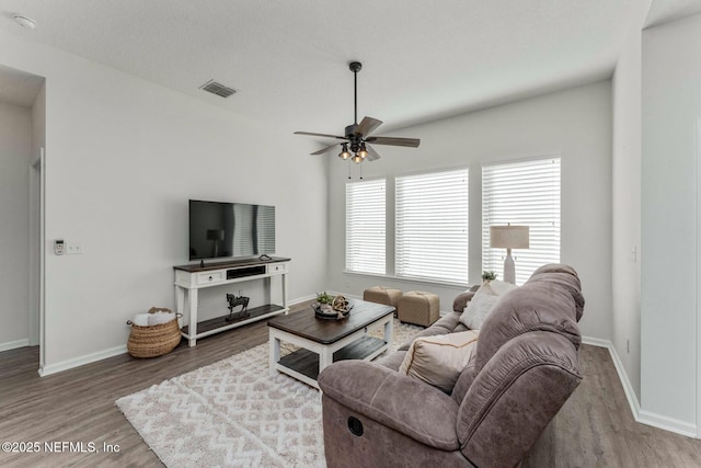 living room featuring a textured ceiling, ceiling fan, and hardwood / wood-style flooring