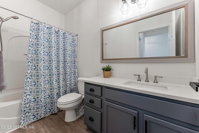 full bathroom with toilet, hardwood / wood-style floors, shower / bathtub combination with curtain, a textured ceiling, and vanity