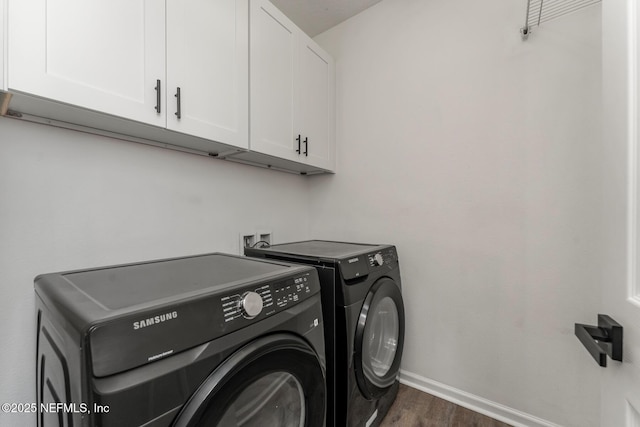 laundry room with dark hardwood / wood-style flooring, washing machine and clothes dryer, and cabinets