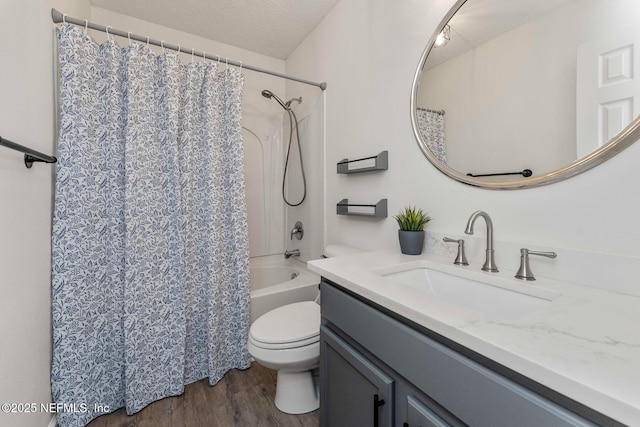 full bathroom featuring toilet, shower / bath combination with curtain, wood-type flooring, a textured ceiling, and vanity